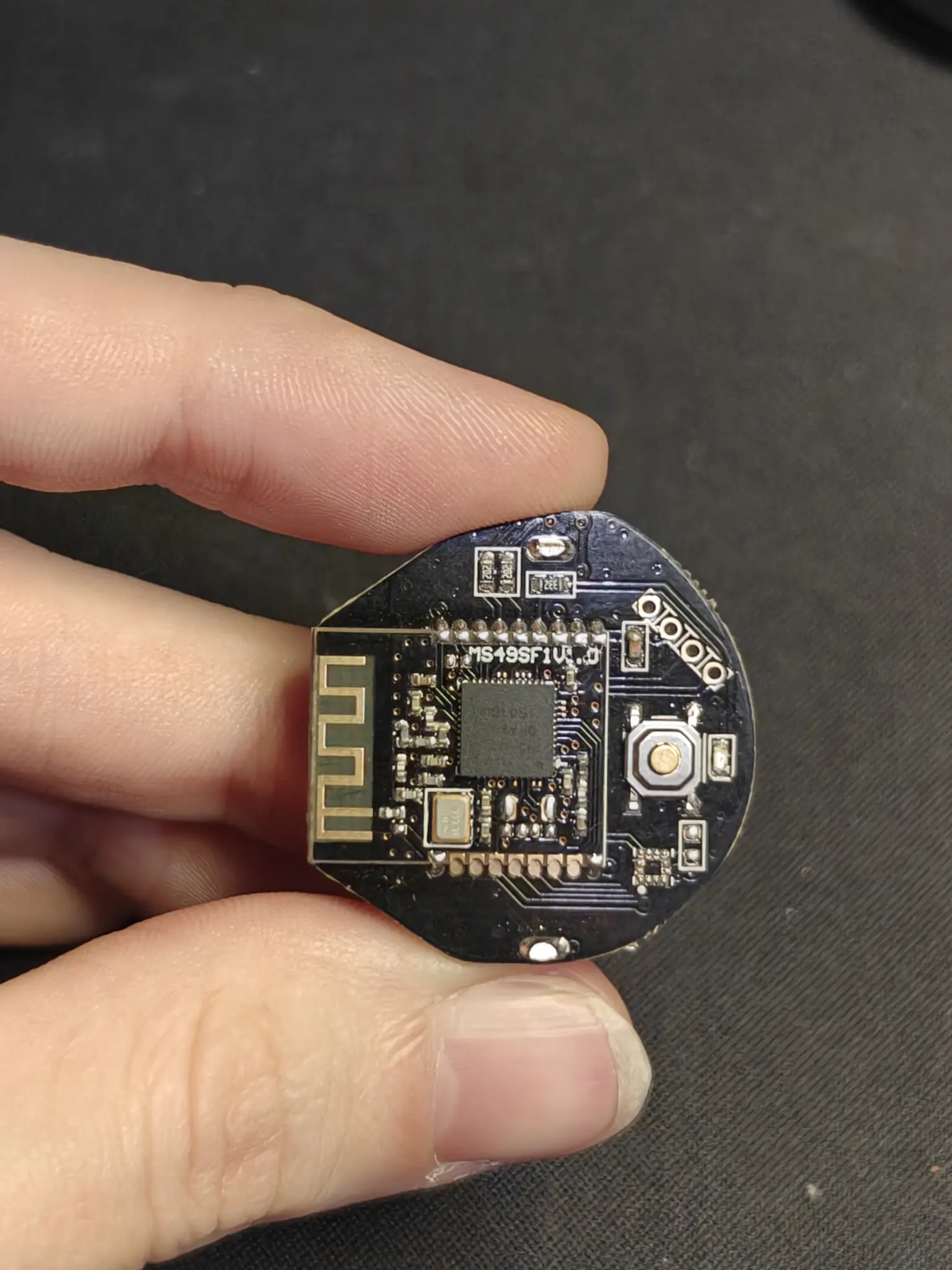 weirdly shaped black PCB, with a chip in the middle marked N51822, and a button on its side