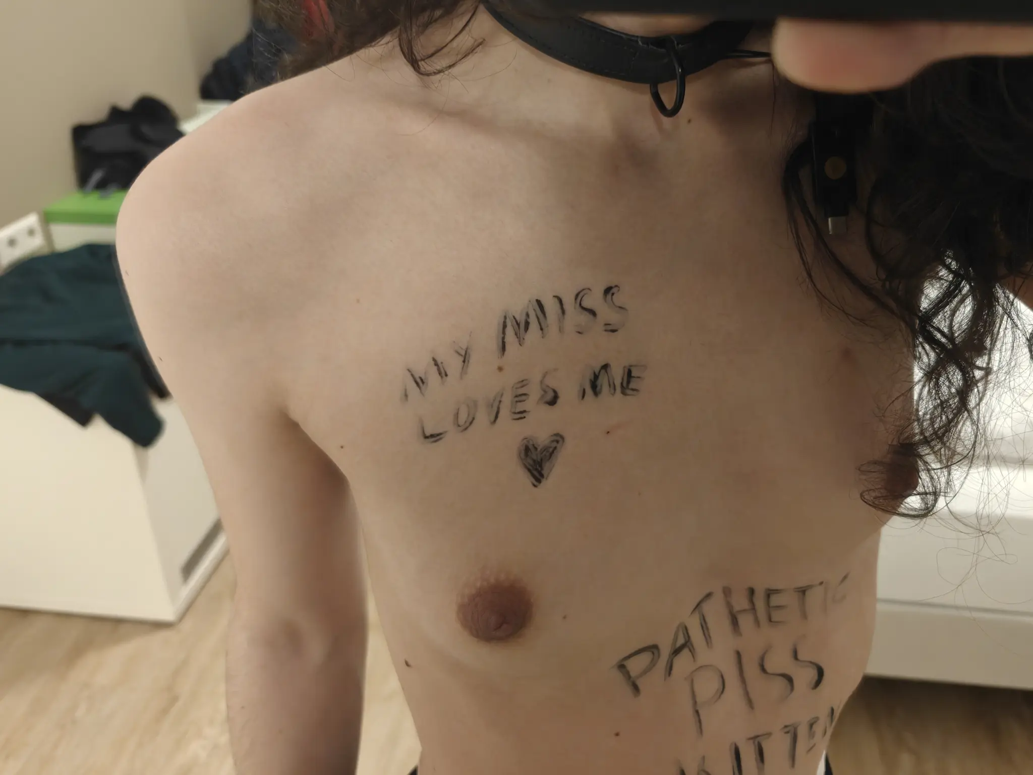 picture taken in the mirror of my hotel room, focused on the right side of my chest, where I have written with a body pen "my Miss loves me 🖤"