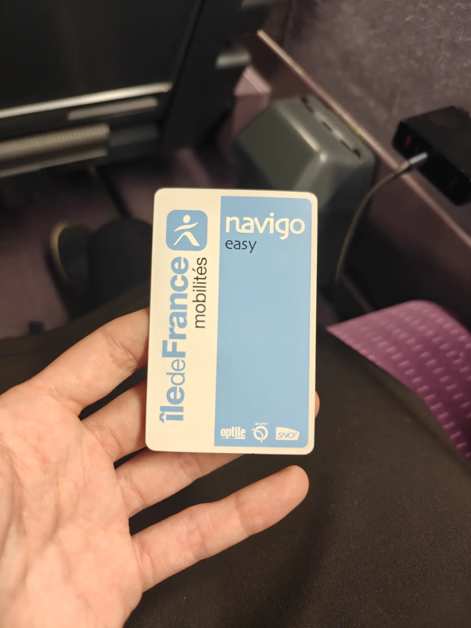 navigo card in my hand, while sitting in a purple TGV seat